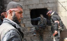 Free Syrian Army fighters move through a hole in a wall during an infiltration operation, April 22.