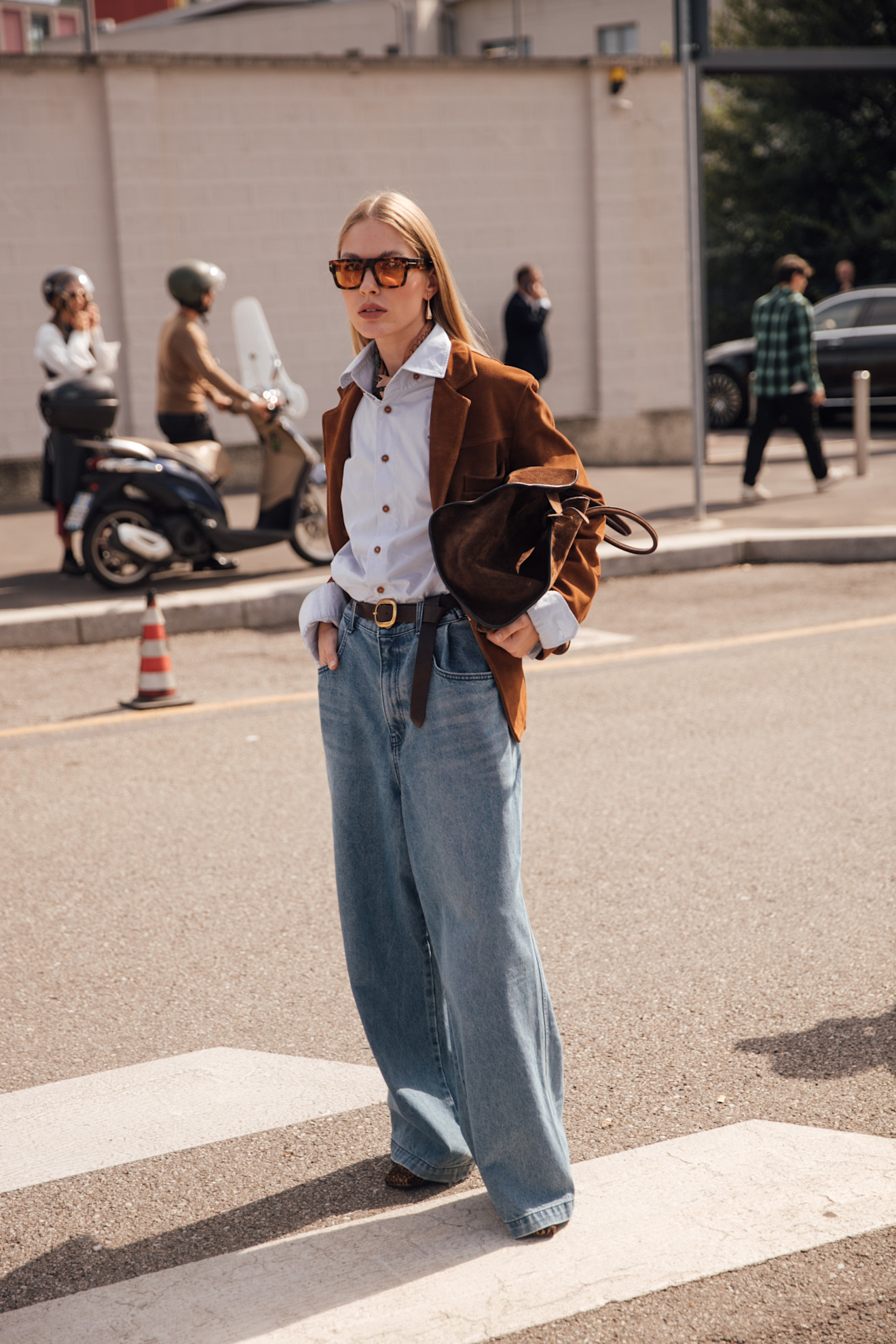 woman wearing suede jacket, button down shirr, and jeans