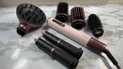 Dreame AirStyle Era multi-styler displayed with diffuser, styling brushes, curling barrels and straightening nozzle attachments
