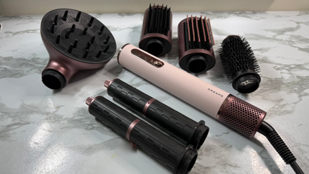 Dreame AirStyle Era multi-styler displayed with diffuser, styling brushes, curling barrels and straightening nozzle attachments