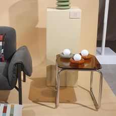 An accent chair next to a side table displaying donut table lamps at the John Lewis spring/summer 2026 press show