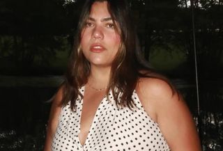 Woman wearing white polka-dot halter-neck dress from Zara.