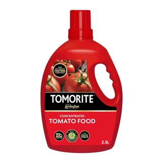 Red tomato food bottle with a handle on the right and a red and black label with tomatoes on it