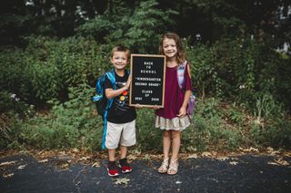Two sibling posing for a first day of school photo