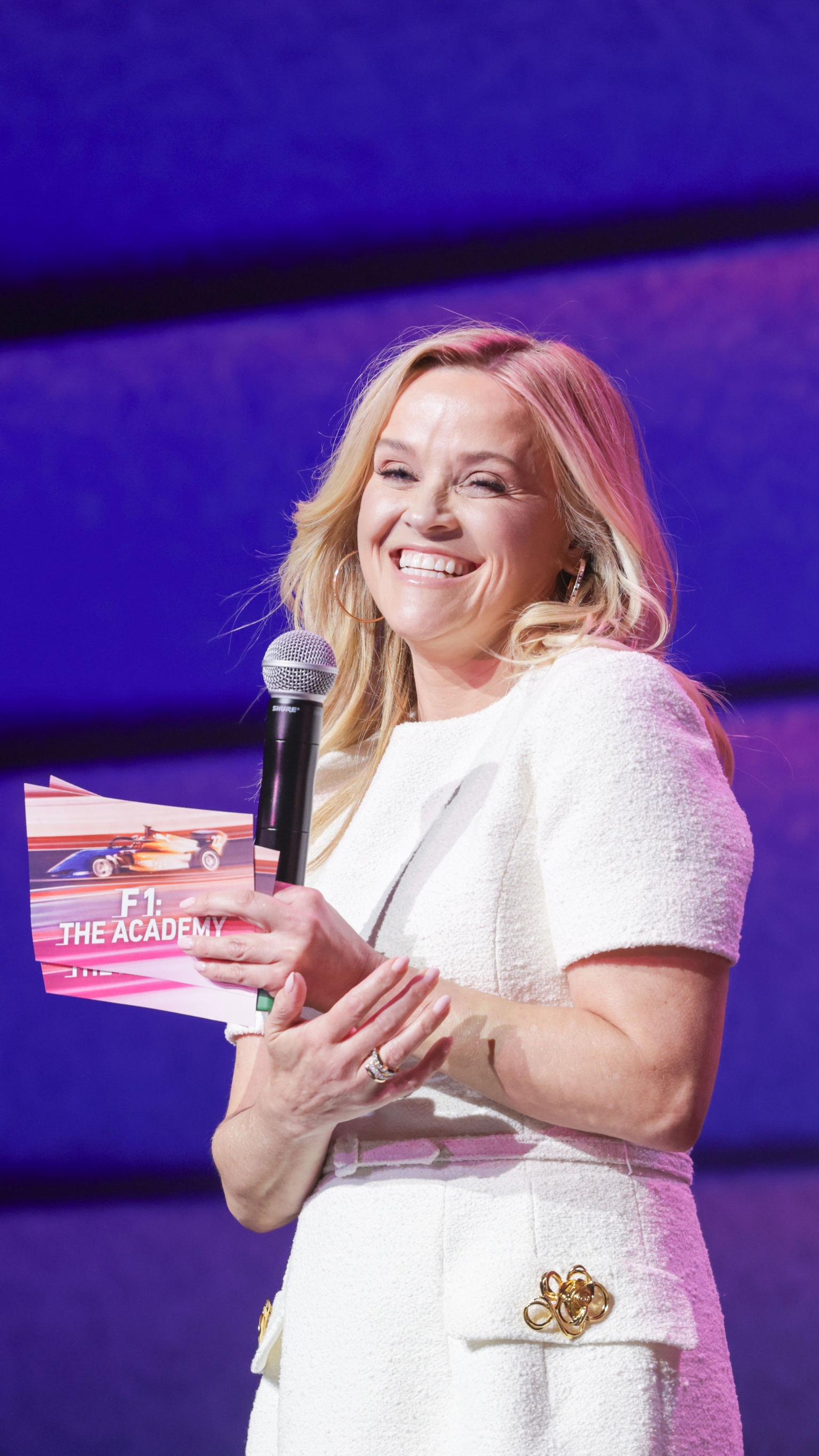 Reese Witherspoon smiles on stage as she attends the screening of F1: The Academy with Hello Sunshine and Netflix at The Fillmore Miami Beach on May 01, 2025
