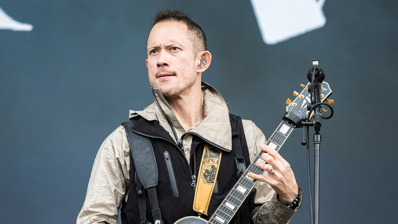 Matt Heafy on stage looking serious with a guitar