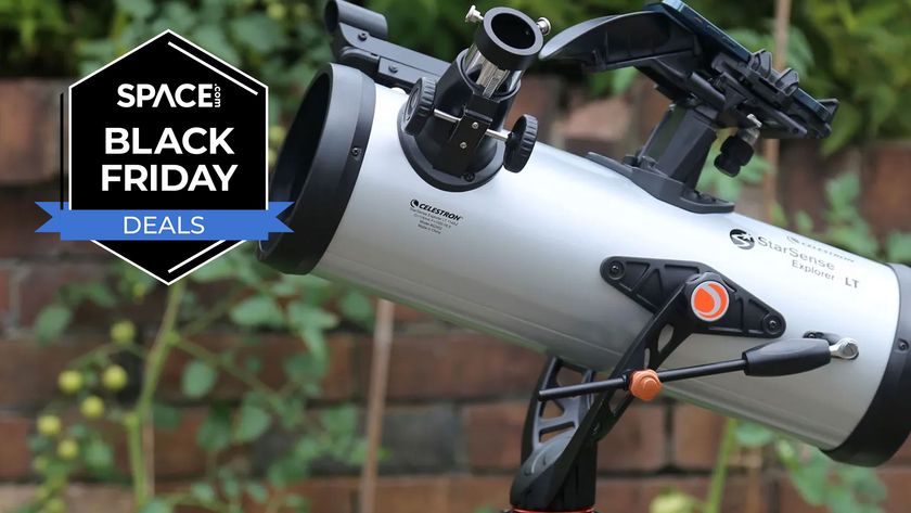 The Celestron StarSense Explorer LT 114AZ telescope with a brick wall behind it with a Space.com Black Friday deals badge in the upper left corner.
