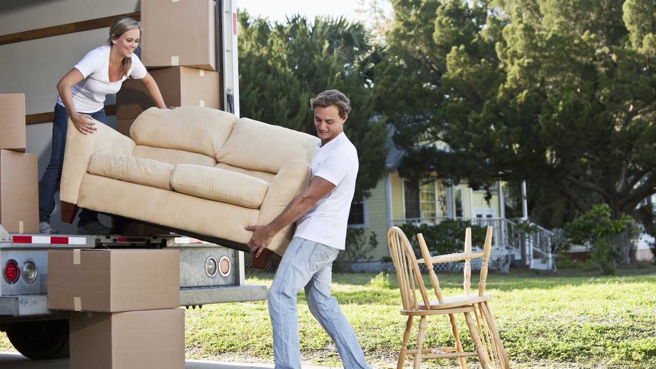 couple moving sofa from a moving van