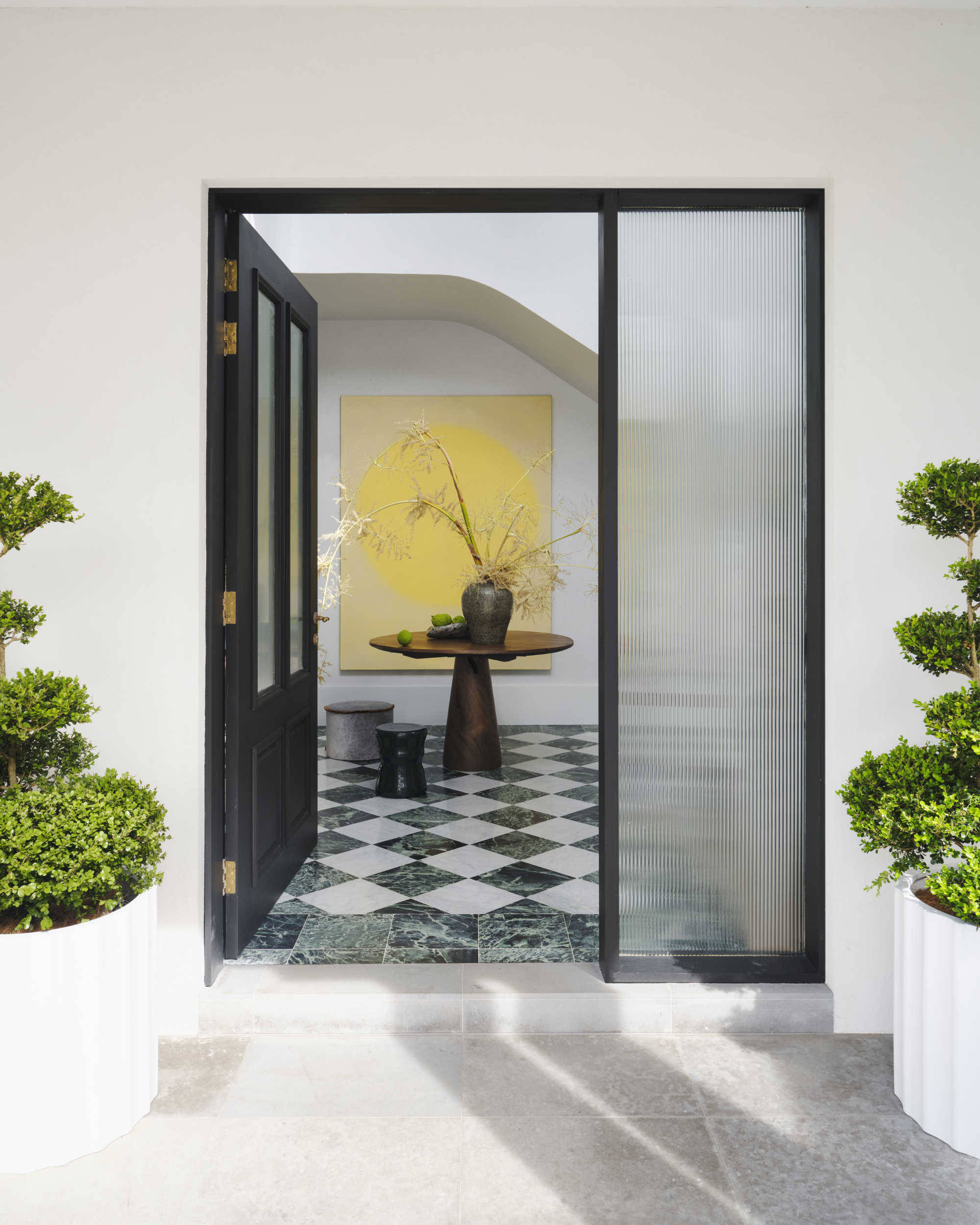 smac studio entryway with checkerboard flooring and a fluted glass front door