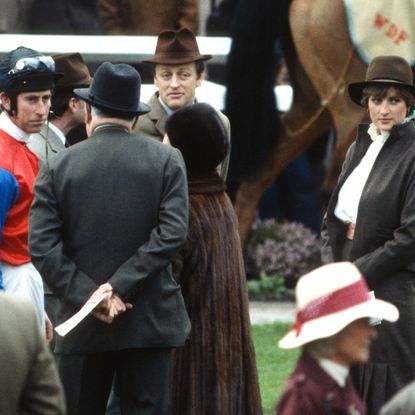 Prince Charles, Prince of Wales (L), Andrew Parker Bowles (3rd L), Princess Margaret, Countess of Snowdon (C), Lady Diana Spencer (2nd R), wearing a brown suit by Bill Pashley and Queen Elizabeth The Queen Mother (R) stand in the parade ring at Sandown Park Racecourse on March 13, 1981 in Sandown, United Kingdom.
