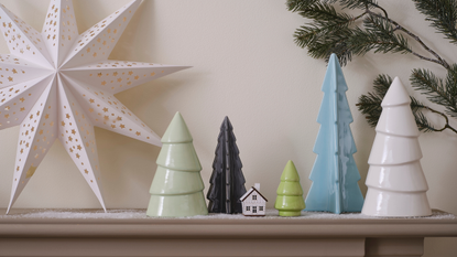 4 ceramic christmas trees on a shelf