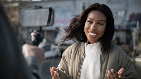 A woman journalist using the new Shure MoveMic outdoors. 