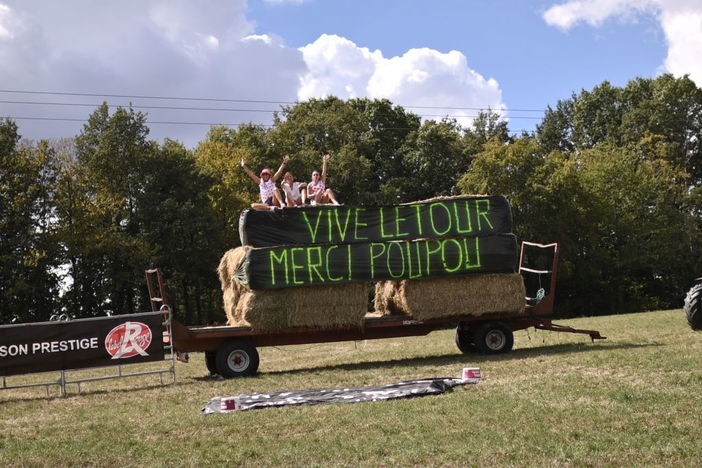 Fans sit on a truck above a banner in tribute to late French cyclist Raymond Poulidor as the pack rides next to his hometown during the 12th stage of the 107th edition of the Tour de France cycling race 218 km between Chauvigny and Sarran on September 10 2020 Photo by Marco BERTORELLO AFP Photo by MARCO BERTORELLOAFP via Getty Images