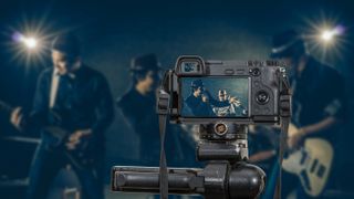 Professional digital Mirrorless camera with microphone recording video blog of Musician band singing a song and playing music instrument,Camera for photographer or Video and Live Streaming concept - stock photo