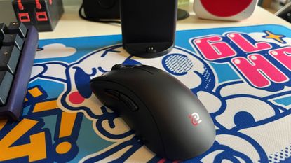 The BenQ Zowie EC2-CW gaming mouse on a colorful mousepad.
