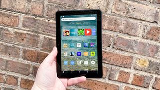 Amazon Fire HD 8 (2022) home screen pictured while held in hand in front of a brick wall