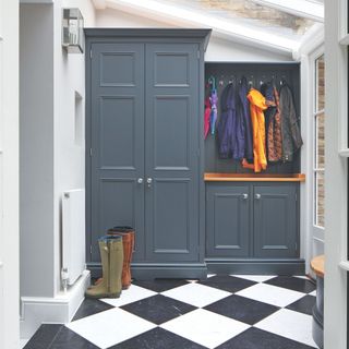 Boot room area with black and white checkered floor and blue cabinetry