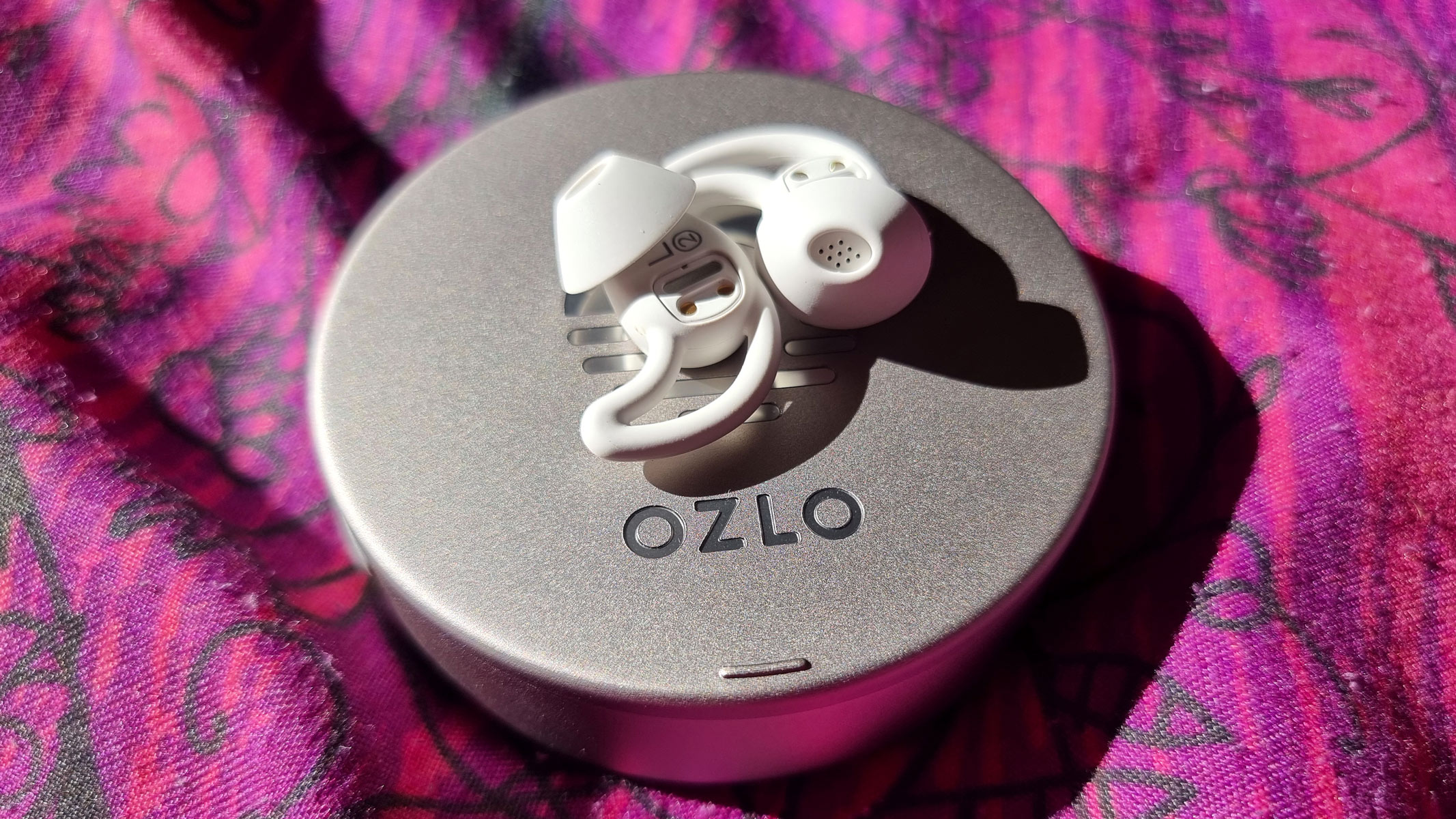 Ozlo Sleepbuds laid out on the top of the charging case