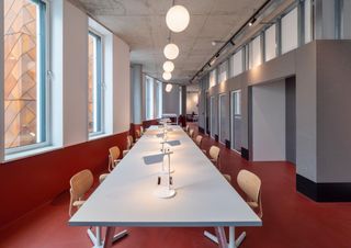 Large white meeting table on red floors