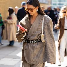 woman in blazer looking at her phone