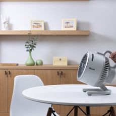 woman's hand holding shark flexbreeze hydrogo fan in apartment living room