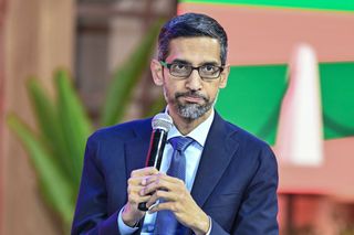 Google CEO Sundar Pichai holding a microphone on stage