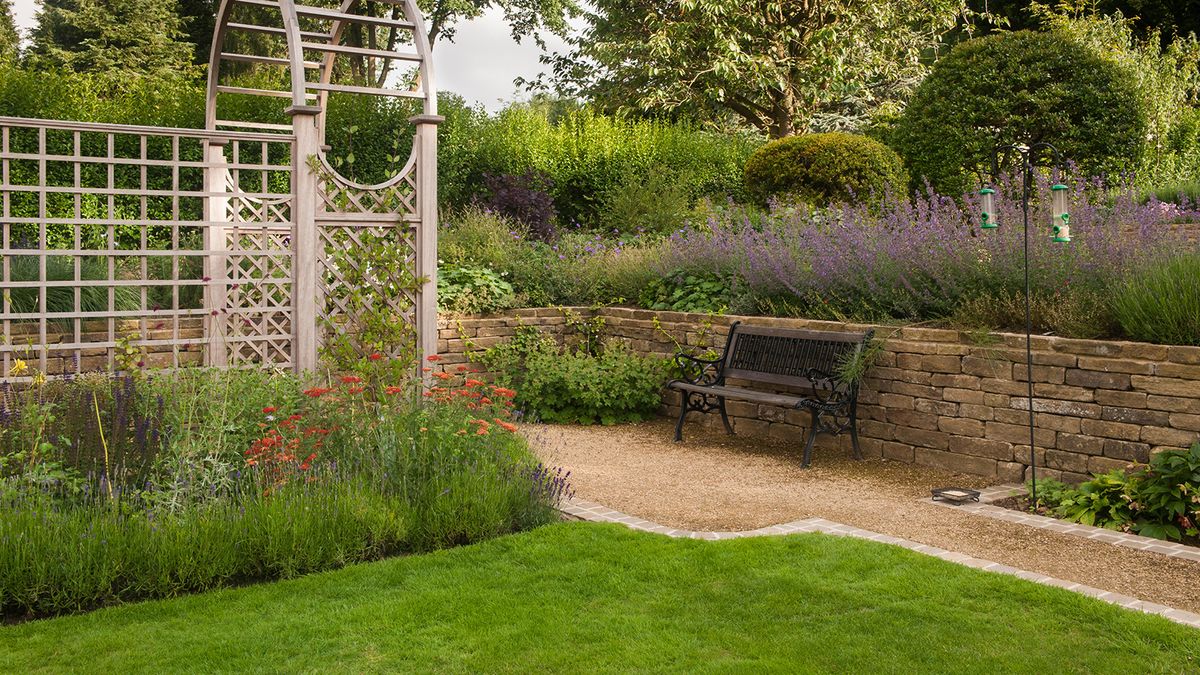 Recently designed and landscaped, a beautiful, traditional garden with arbour and borders, in summer 