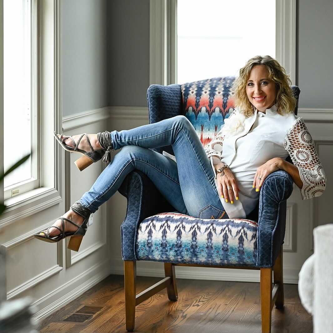A woman, Shannon Allen, poses in a chair.