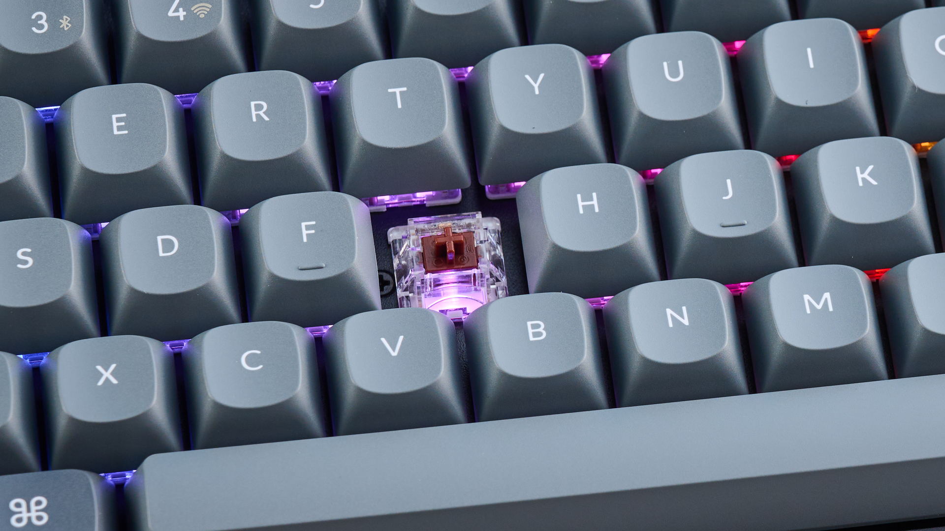 Keychron K8 Max mechanical keyboard in gray photographed on a blue background