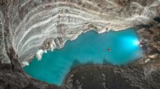 View of an underground thermal lake from above inside a cave.