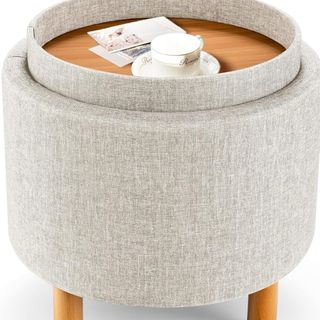 grey fabric footstool with warm wood tray and feet on a white background