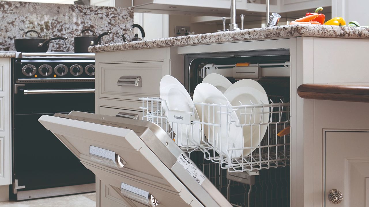 A kitchen with an open, loaded dishwasher