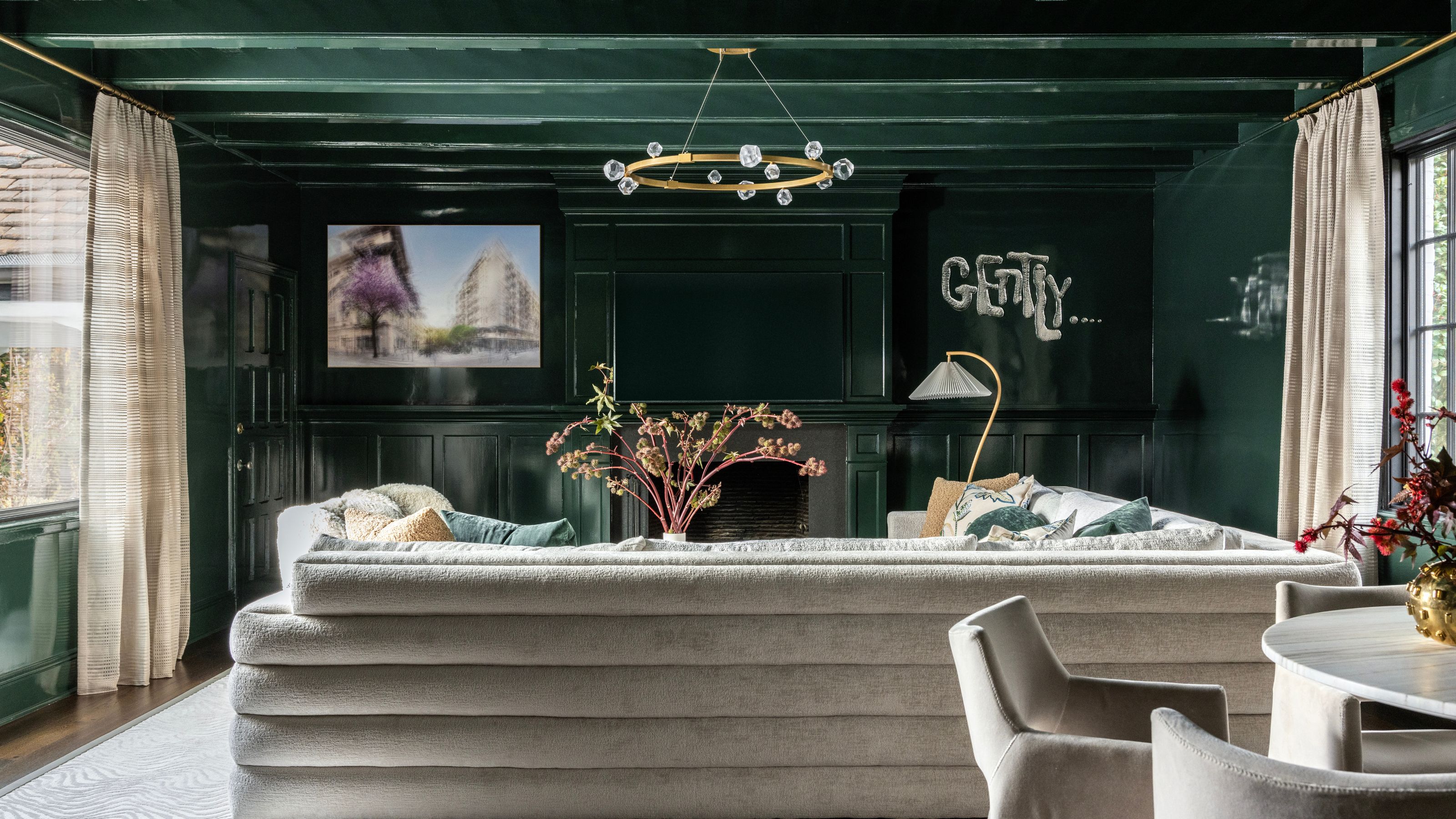 green, color-drenched living room with beige couch and dining table