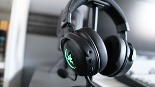 Razer Kraken V3 Hypersense pictured on desk hanging from a stand