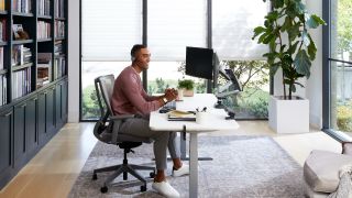 A person working at a desktop computer at home.