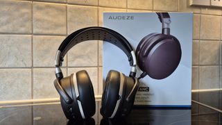 A picture of the Audeze Maxwell 2 ANC gaming headset on a shiny surface with pale tiles in the background