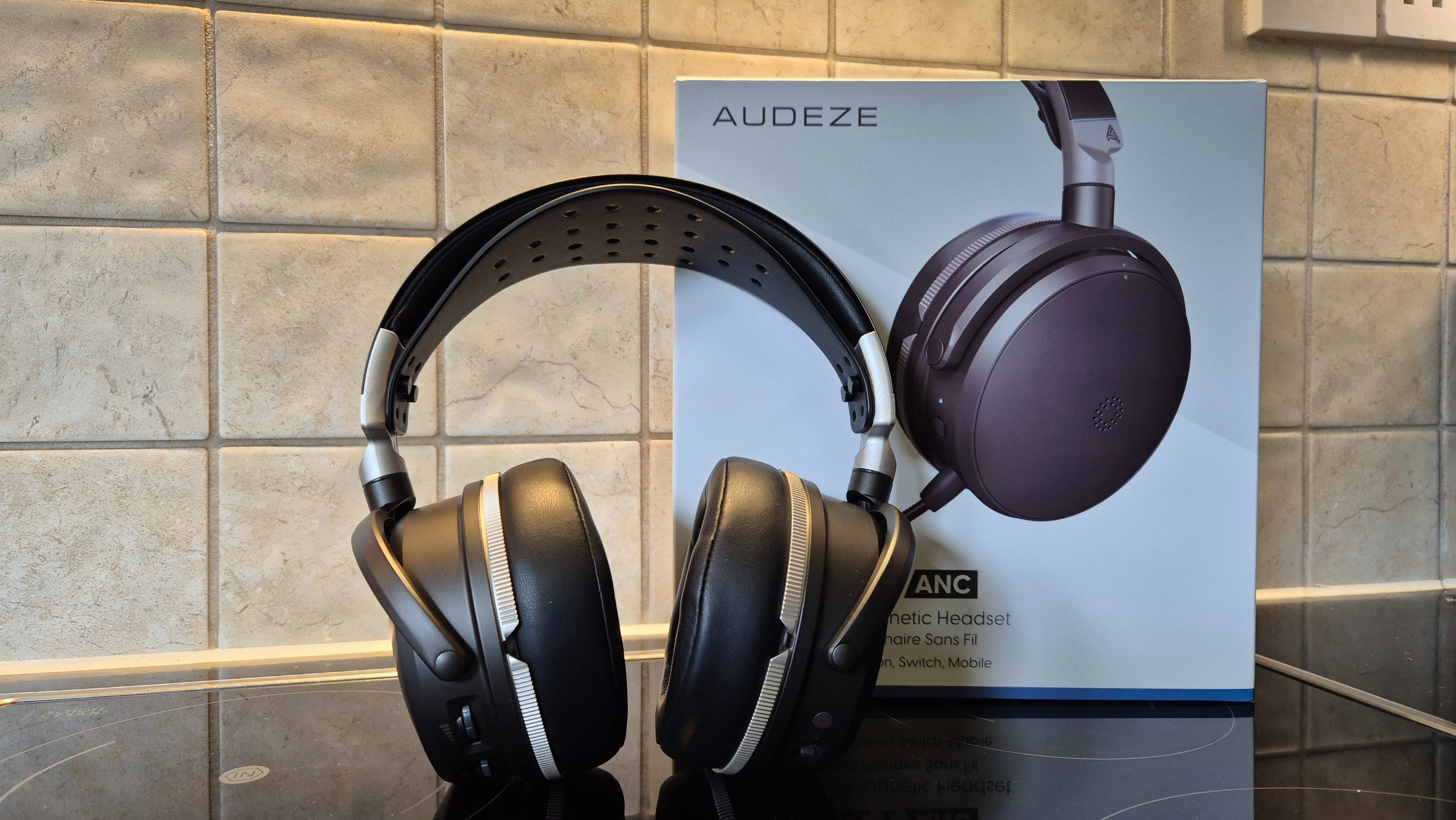 A picture of the Audeze Maxwell 2 ANC gaming headset on a shiny surface with pale tiles in the background