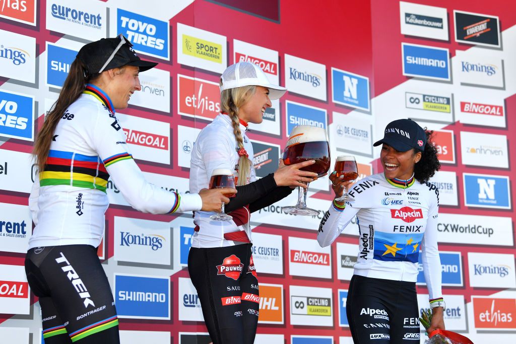 ZONHOVEN BELGIUM OCTOBER 24 LR Lucinda Brand of The Netherlands and Team Baloise Trek Lions on second place race winner Denise Betsema of The Netherlands and Team Pauwels Sauzen Bingoal and Ceylin Del Carmen Alvarado of The Netherlands and Team Alpecin Fenix on third place celebrate with a beer on the podium ceremony after the 25th Zonhoven UCI CycloCross Worldcup 2021 Womens Elite CXWorldCup UCIcyclocrossWC zonhoven on October 24 2021 in Zonhoven Belgium Photo by Luc ClaessenGetty Images