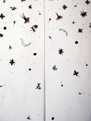 White wall with small black flower shapes