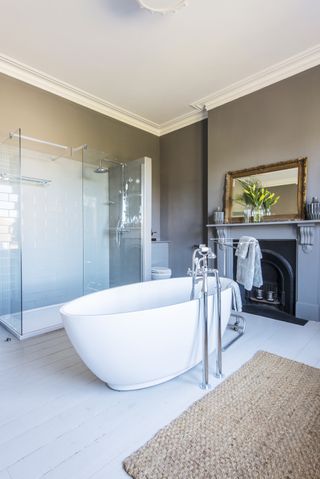 Bathroom with fireplace, large oval bath, floorstanding tap and walk-in shower