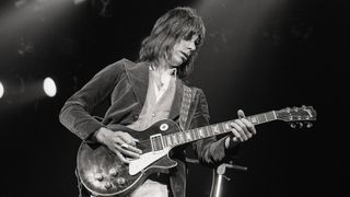 Jeff Beck performing on stage, playing Gibson Les Paul guitar