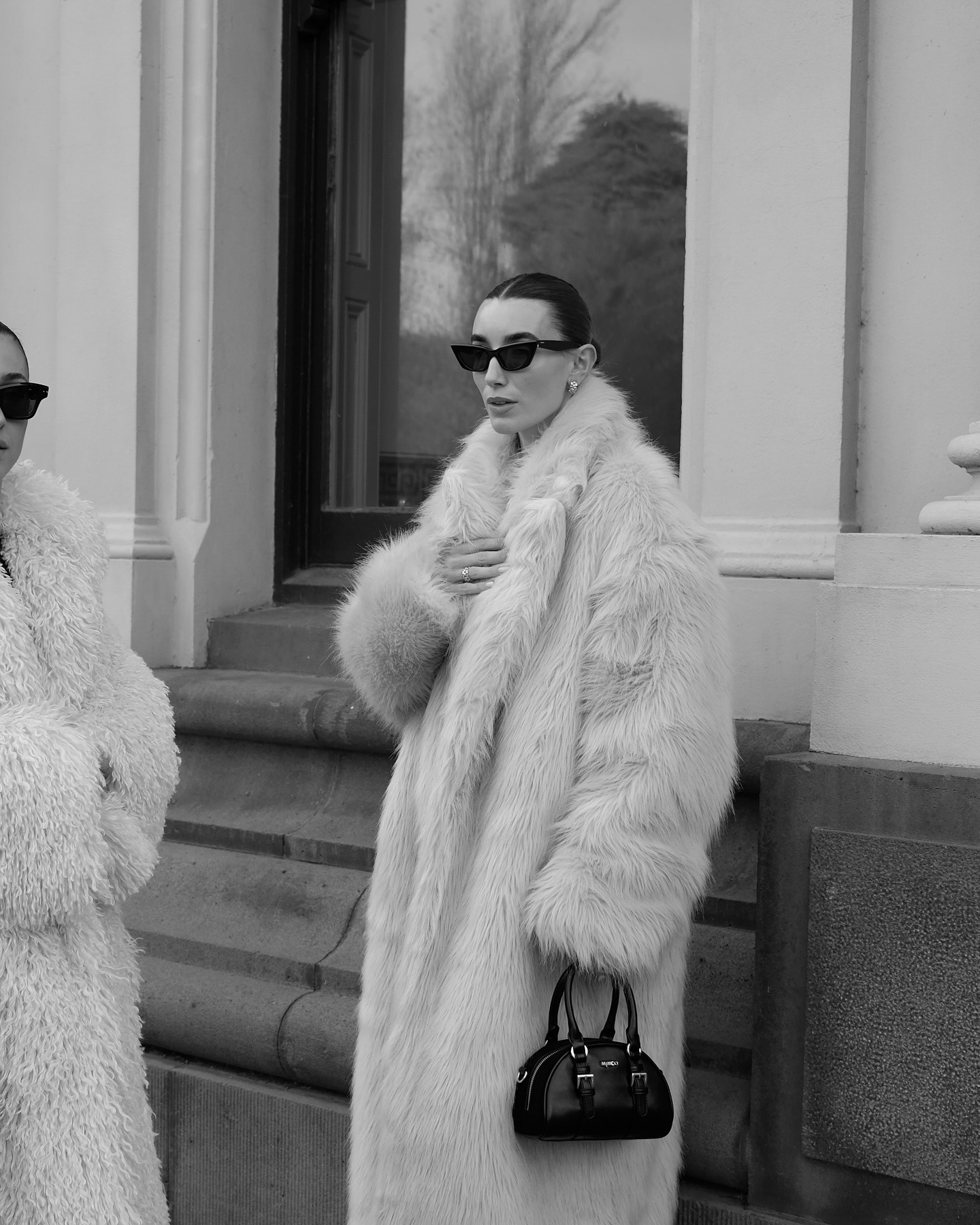 Millie wears a black bomber jacket, black jeans, and Ugg boots.