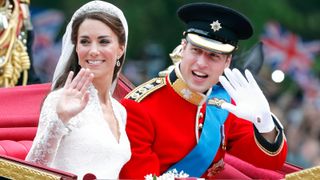 Catherine, Duchess of Cambridge and Prince William, Duke of Cambridge (wearing his red tunic uniform of the Irish Guards, of which he is Colonel) travel down The Mall, on route to Buckingham Palace, in the 1902 State Landau horse drawn carriage following their wedding ceremony at Westminster Abbey on April 29, 2011 in London, England