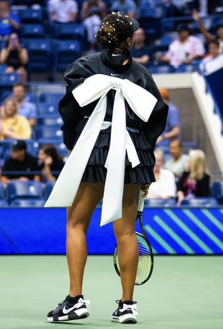 Naomi Osaka wears a black nike tennis set with white statement bows