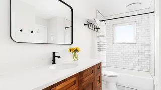 White bathroom with wooden storage