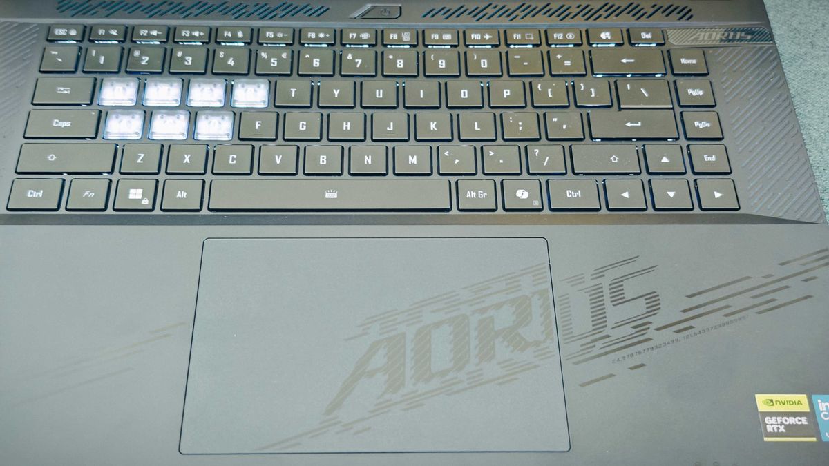 A Gigabyte Aorus Master 16 laptop on a green sofa