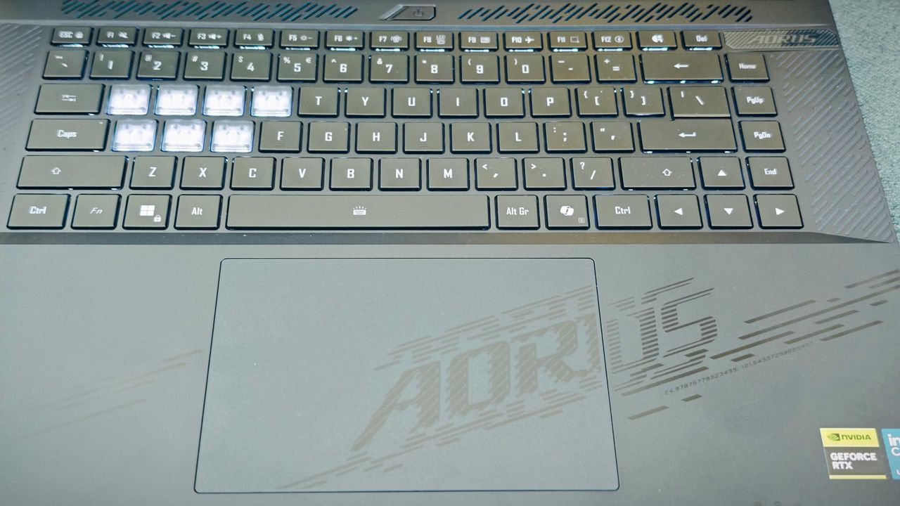 A Gigabyte Aorus Master 16 laptop on a green sofa