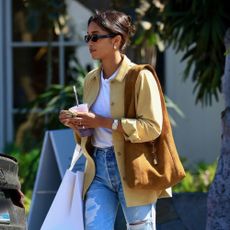 Laura Harrier styles a yellow jacket with a brown bag