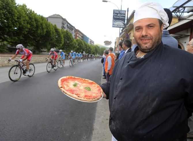 A pizza maker shows off his goods during the Giro