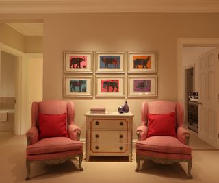 spacious landing area with two pink armchairs and a gallery wall